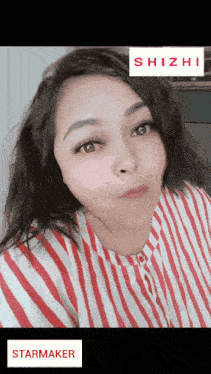 a woman wearing a red and white striped shirt with a starmaker sticker on the bottom