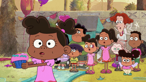 a girl in a pink dress holds a cupcake in front of a group of children