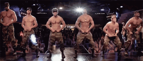 a group of men in military uniforms are dancing in front of a crowd .