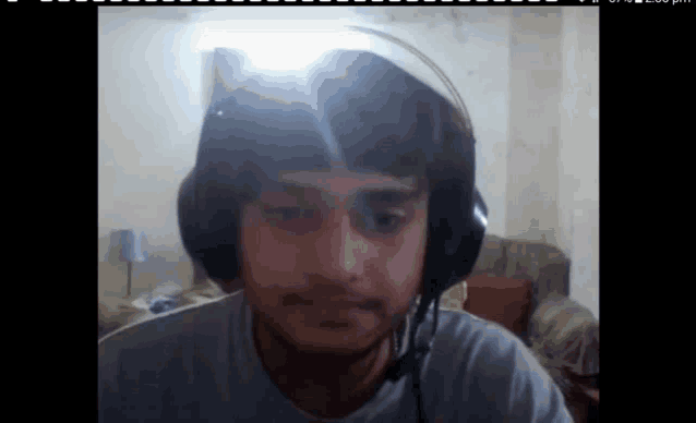 a man wearing headphones looks at the camera in a room