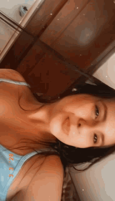 a woman in a blue tank top takes a selfie with a date stamp of 3/30