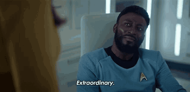 a man in a star trek uniform is sitting in a chair and says extraordinary