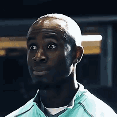 a man with a surprised look on his face is wearing a blue jacket .