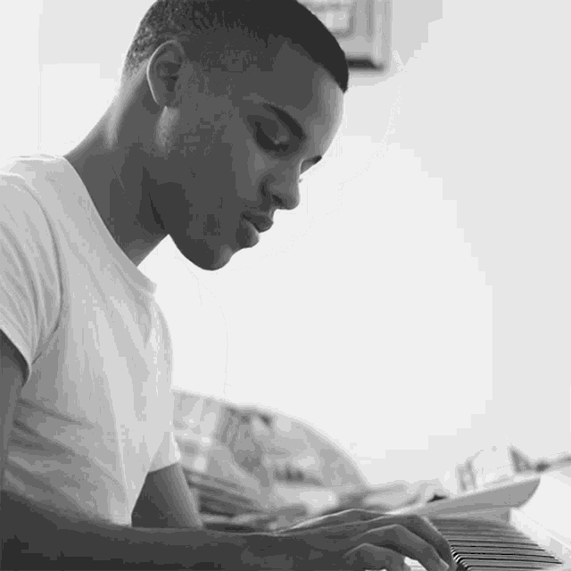 a man in a white shirt is playing the piano