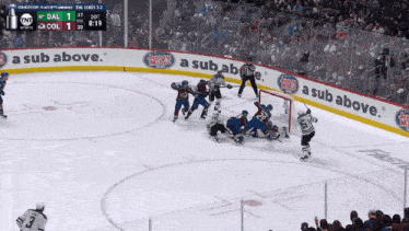 a hockey game is being played in front of a banner that says " a sub above "