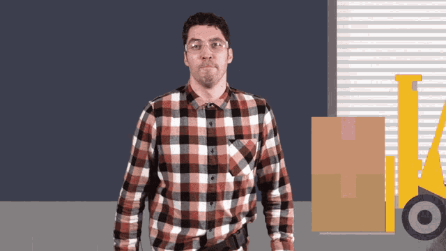 a man in a plaid shirt is standing in front of a yellow forklift