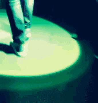 a person 's feet are shown in a blurry photo with a green light behind them