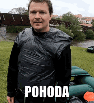 a man is wrapped in a black plastic bag and the word pohoda is above him