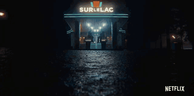 a woman sits at a table in a dark room with a netflix logo behind her
