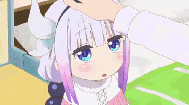 a girl with horns and blue eyes is being patted on the forehead