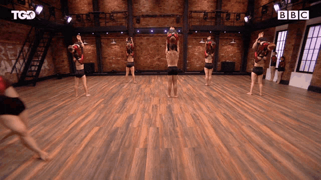 a group of people are dancing in a room with a bbc logo