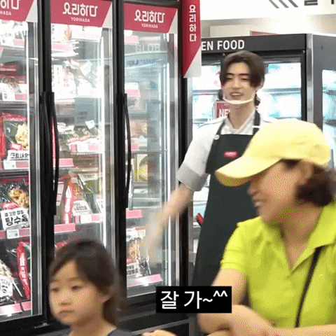 a woman in a yellow hat stands in front of a refrigerator that says en food on it