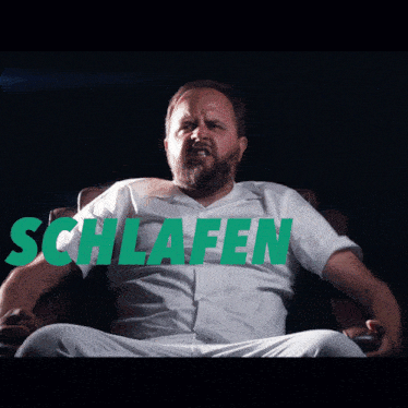 a man is sitting in a chair with his eyes closed and the words " schlafen ist verboten " behind him
