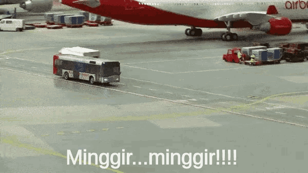 a red airbus is being towed by a bus on an airport tarmac