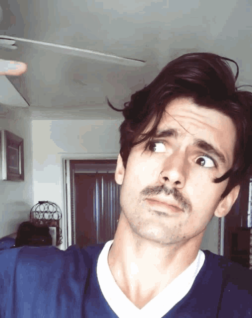 a man with a mustache is making a silly face