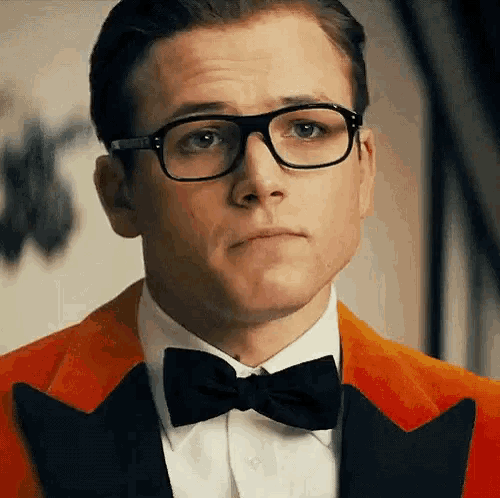 a close up of a man wearing glasses and a bow tie .