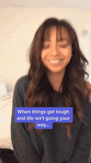 a woman is smiling with a caption that says " when things get tough and life isn 't going your way "