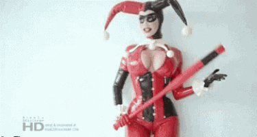 a woman dressed as harley quinn is holding a red bat