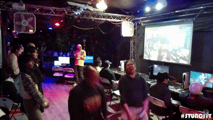 a group of people are gathered in a room with a projector screen that says #stuncity on it