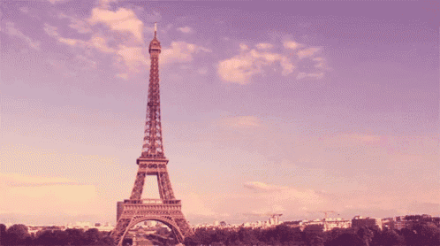 the eiffel tower in paris against a purple sky with clouds