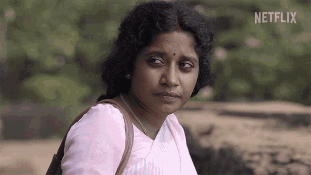 a woman in a pink shirt with a netflix logo in the corner