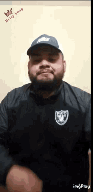 a man with a beard wearing a nike hat