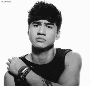a black and white photo of a young man wearing a black tank top and bracelets