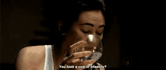 a woman is drinking a glass of wine and smoking a cigarette while saying you took a vow of chastity