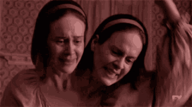 two women are sitting next to each other with fx written on the bottom right
