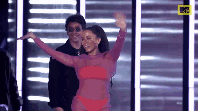 a woman in a red bikini is dancing on a stage with a mtv logo in the corner