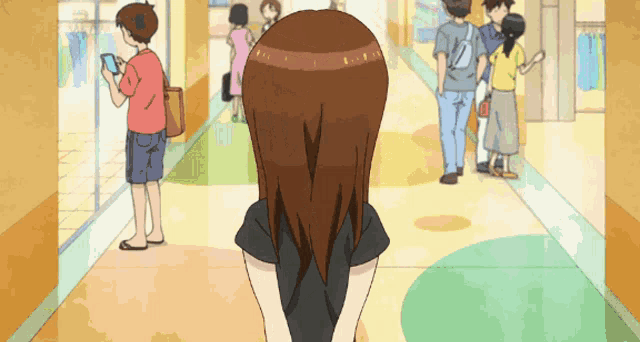 a woman in a black shirt is standing in a hallway