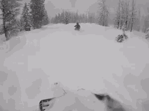 a person is riding a snowmobile down a snow covered road