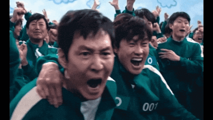 a group of people are playing a game called squid game and one of the players has the number 001 on his shirt .