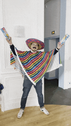 a man wearing a sombrero and a poncho is holding up two tubes of toothpaste