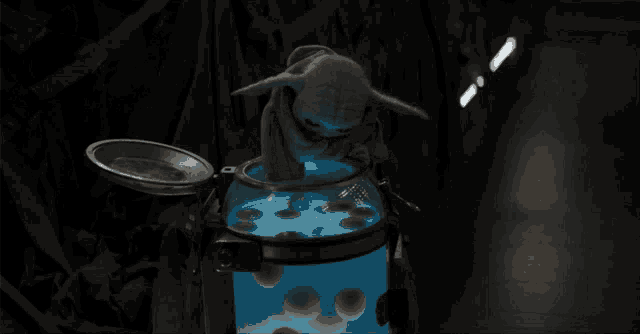 a stuffed animal is sitting in a container with a blue light on it
