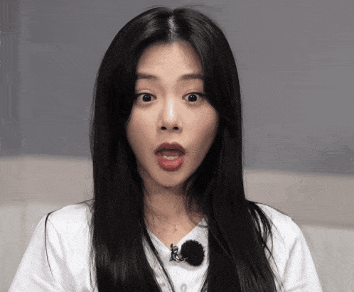 a woman with long black hair is wearing a white shirt
