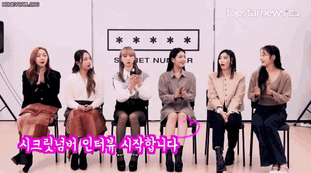 a group of girls are sitting in front of a sign that says topstarnews