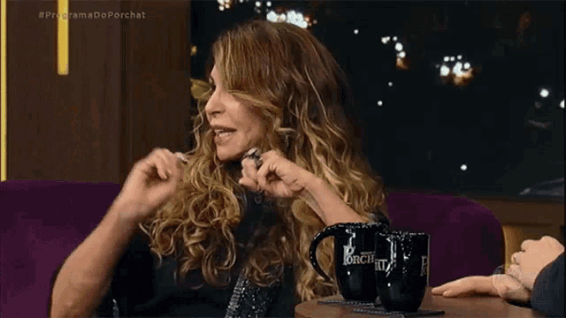 a woman is sitting at a table with two coffee mugs that say porchat