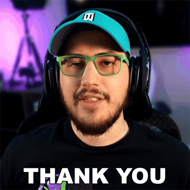 a man with a beard wearing headphones and glasses says thank you