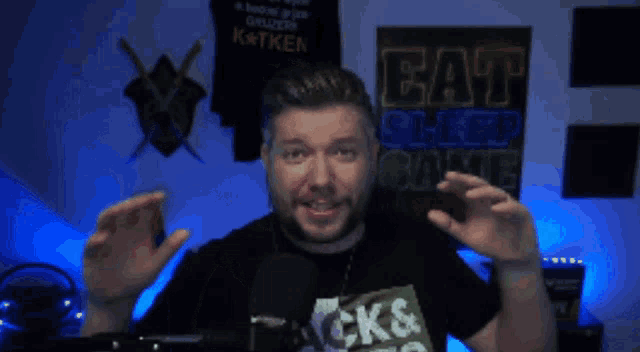 a man in front of a poster that says eat sleep game