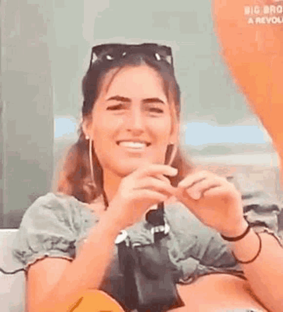 a woman is sitting on a couch wearing sunglasses and holding a camera .