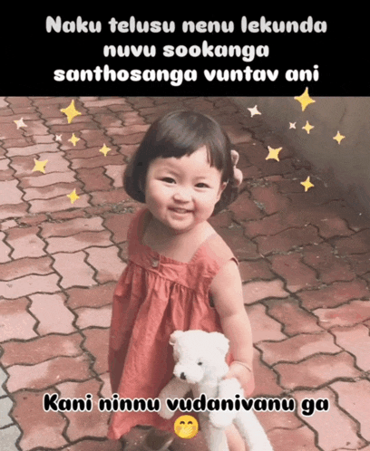 a little girl in a red dress is holding a teddy bear and smiling