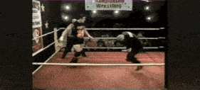 two wrestlers are fighting in a ring with a sign that says wrestling