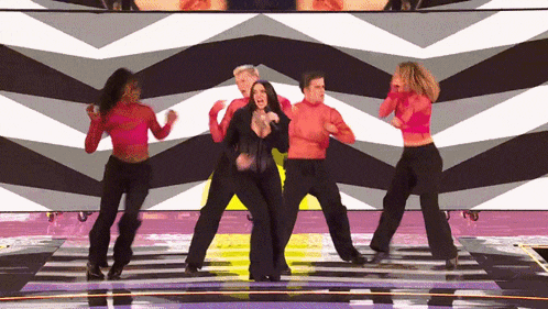 a group of people are dancing together on a stage
