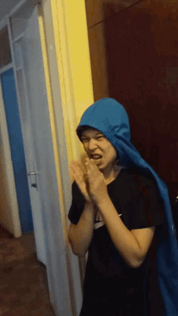 a boy wearing a blue hooded cape and a nike shirt