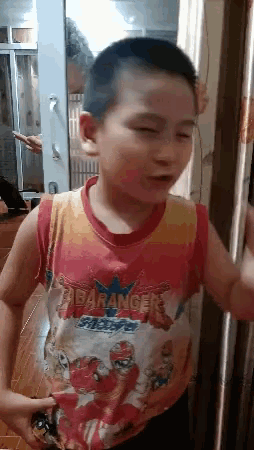 a young boy wearing a red and yellow shirt with the word rangers on it