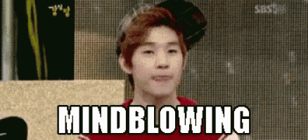 a young man is making a funny face with the words mindblowing written on the screen behind him .