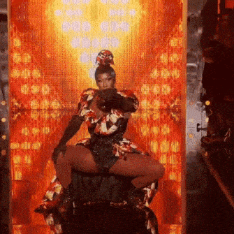 a woman in a colorful dress is kneeling down in front of a wall of lights