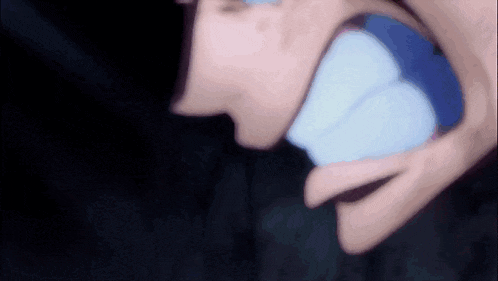 a close up of a person 's mouth with a blue object in it .