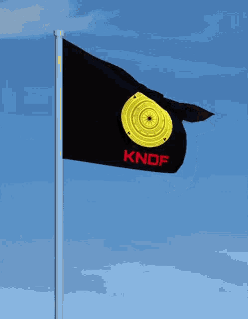 a black flag with knof written on it is flying in the wind